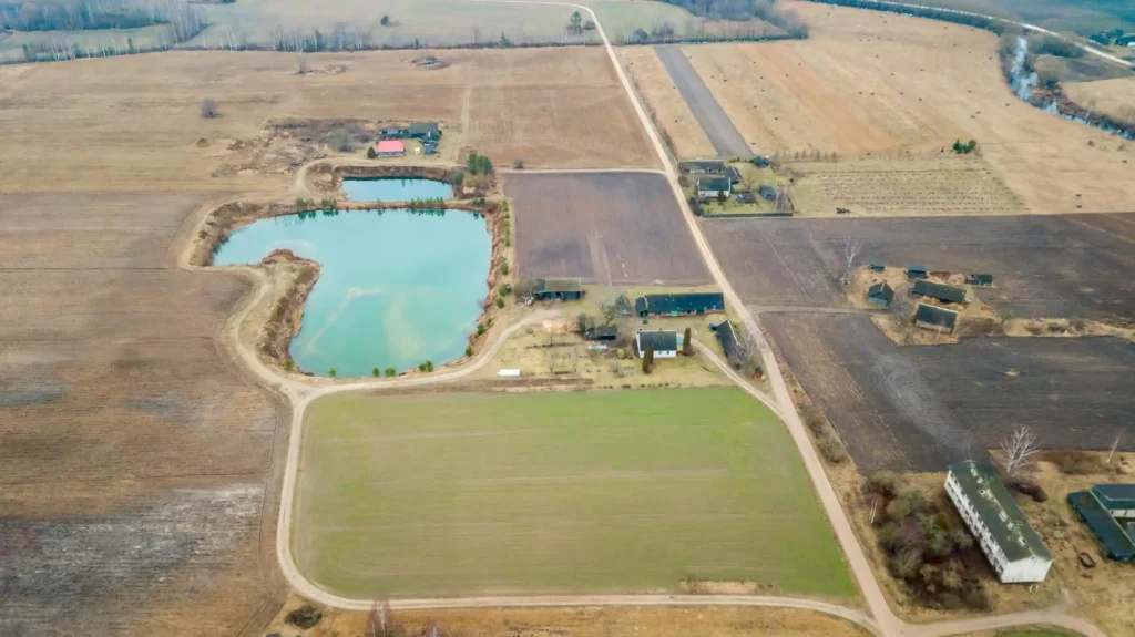 aerial-view-rural-landscape-with-pond-scattered-buildings_664057-6483-scaled